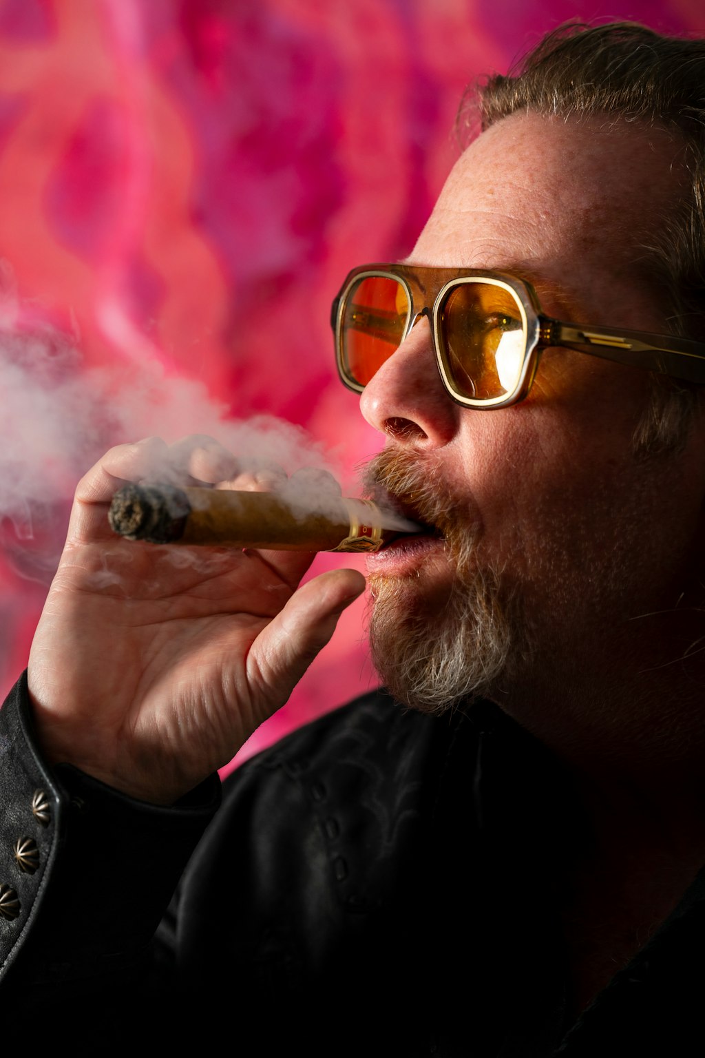 person with glasses smoking cigar