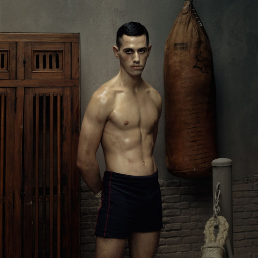 young man with shorts in front of boxing ball