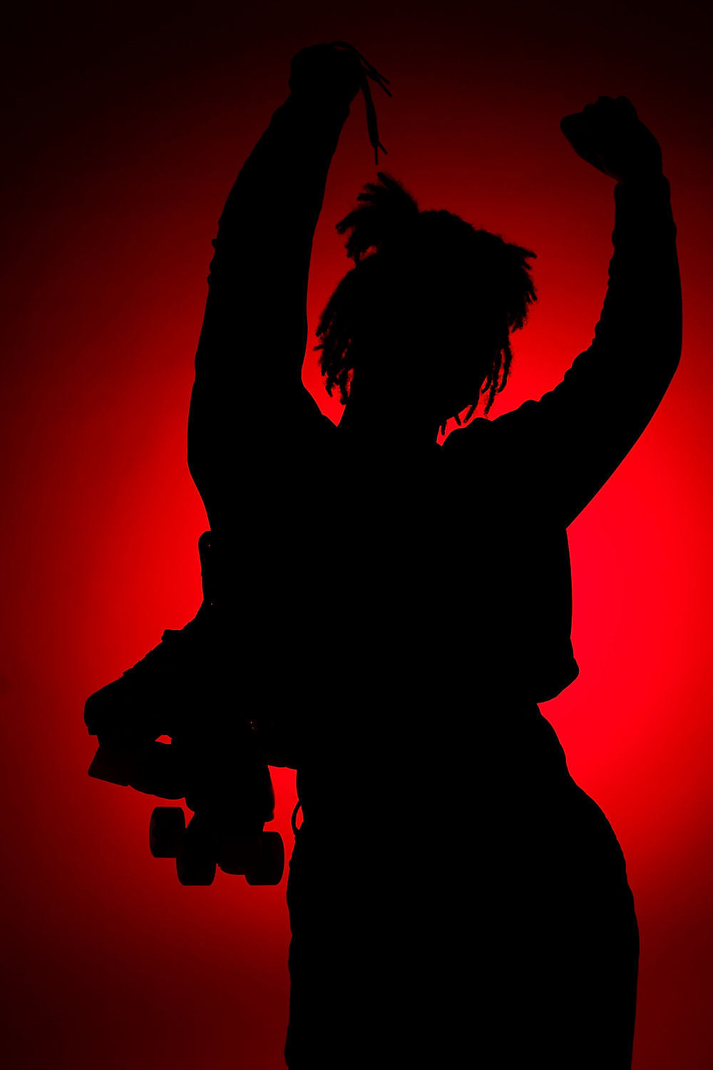 Silhouette of a person holding roller skates with arms raised, set against a red background.