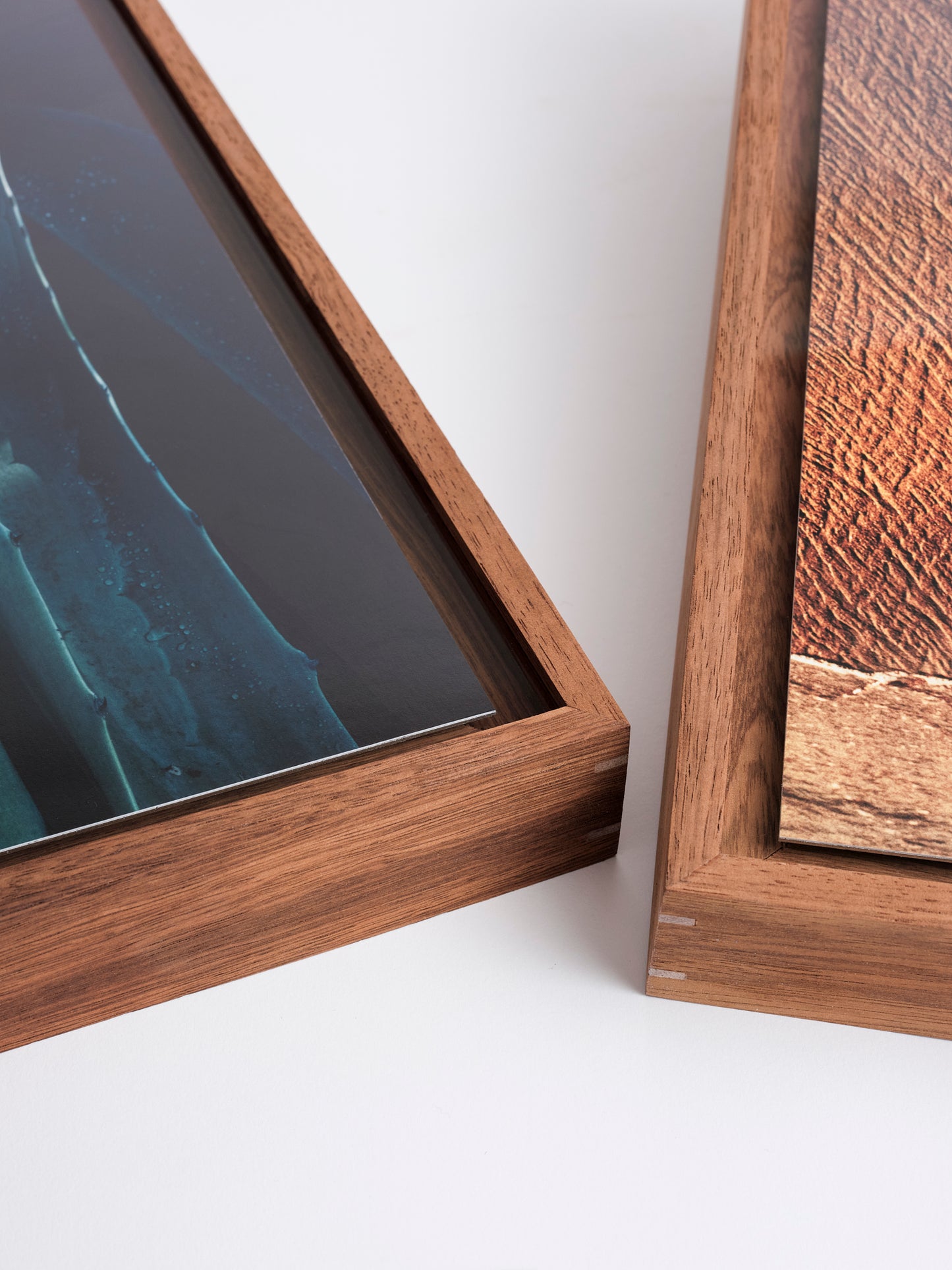 Close-up of two wooden picture frames on a white surface