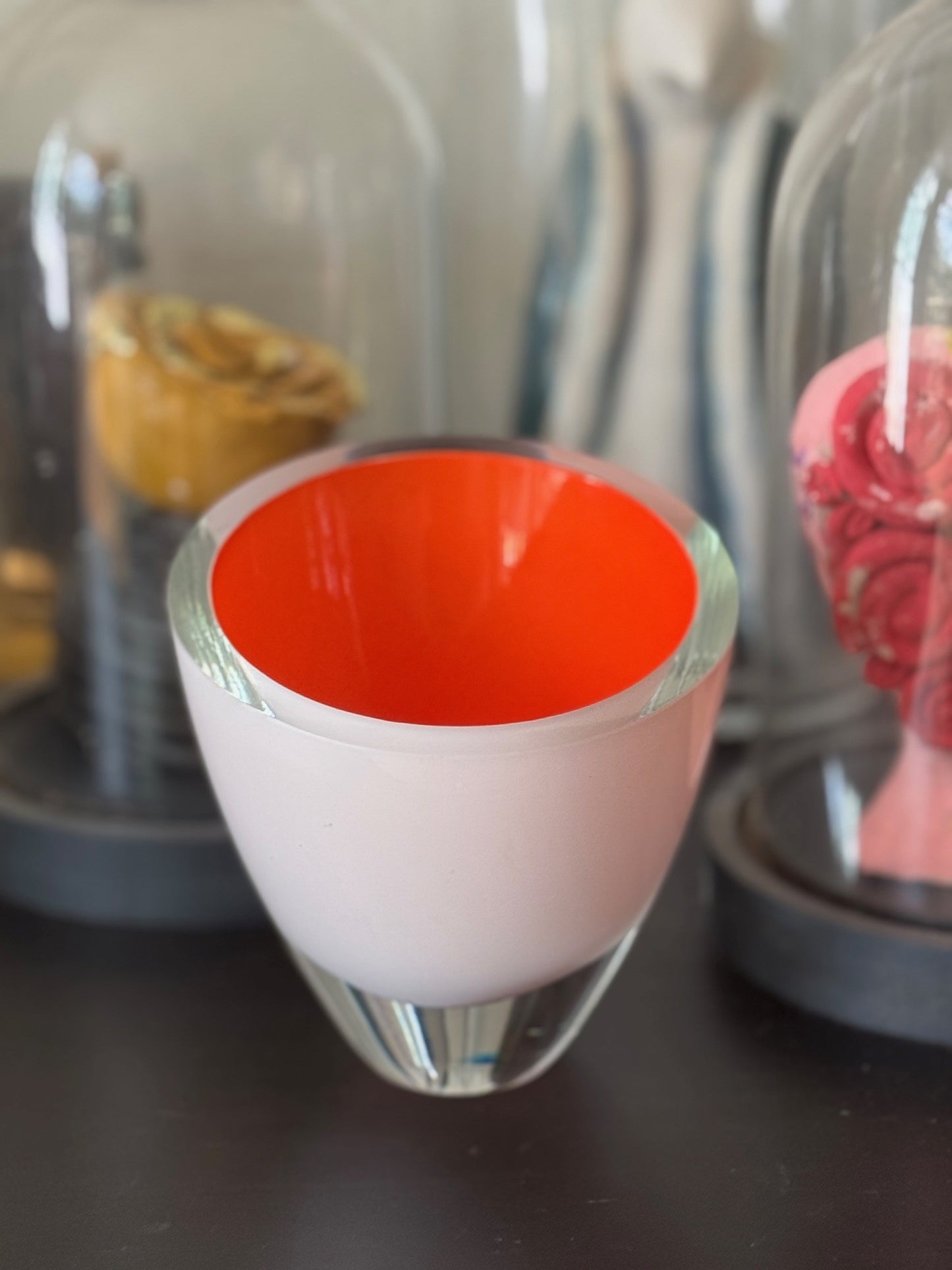 Clear glass container with a red interior on a dark surface