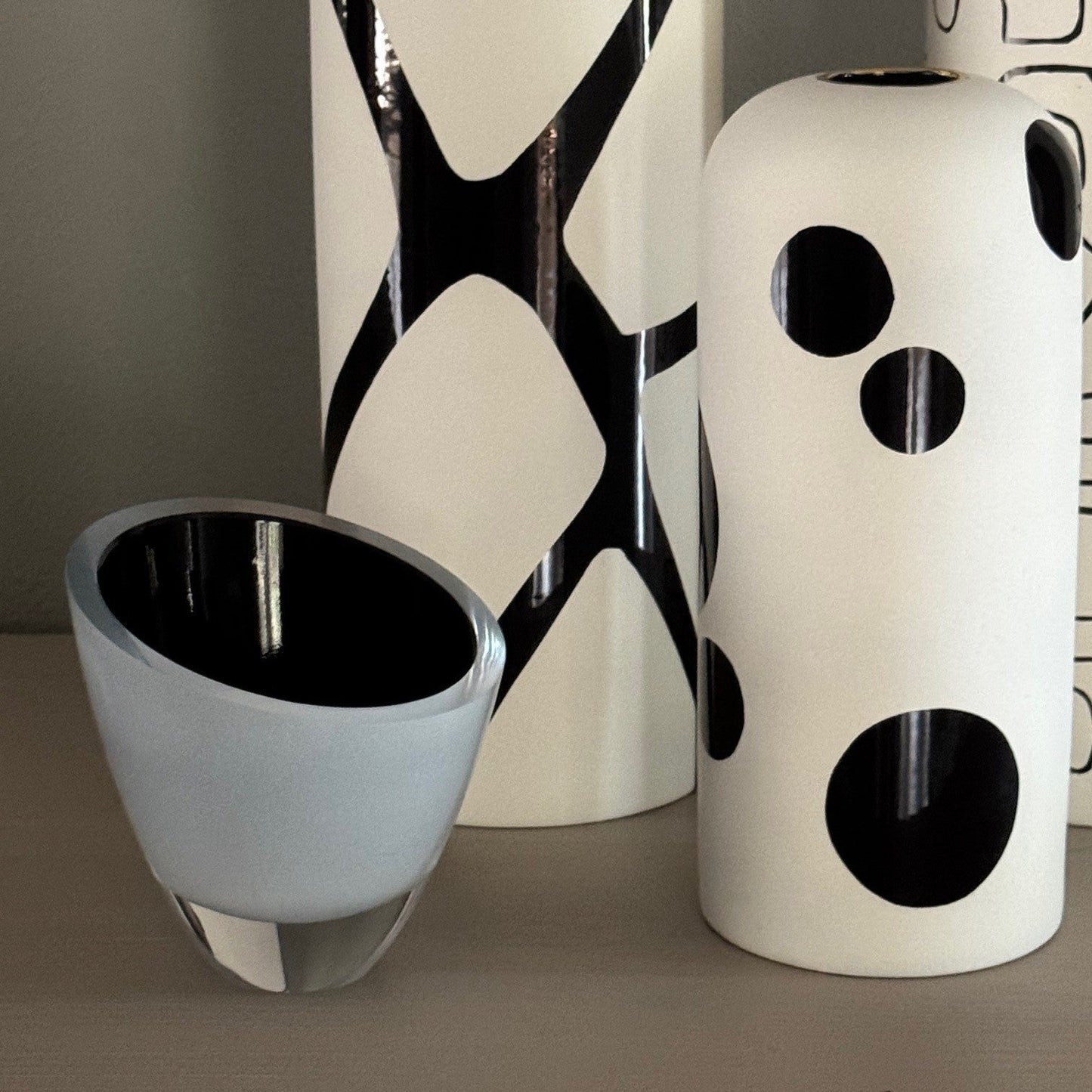 Decorative vases with black abstract patterns on a neutral background