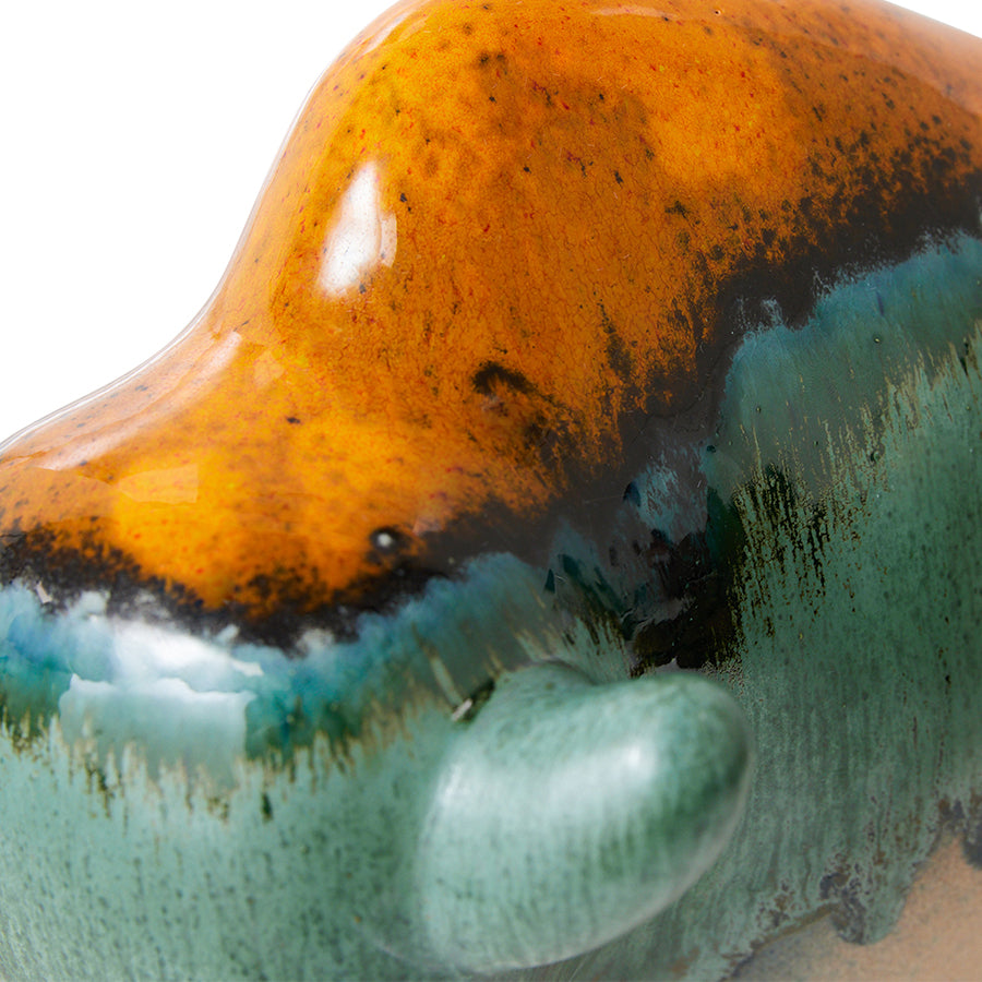 detail of ceramic bull with orange, blue and green reactive glaze finish