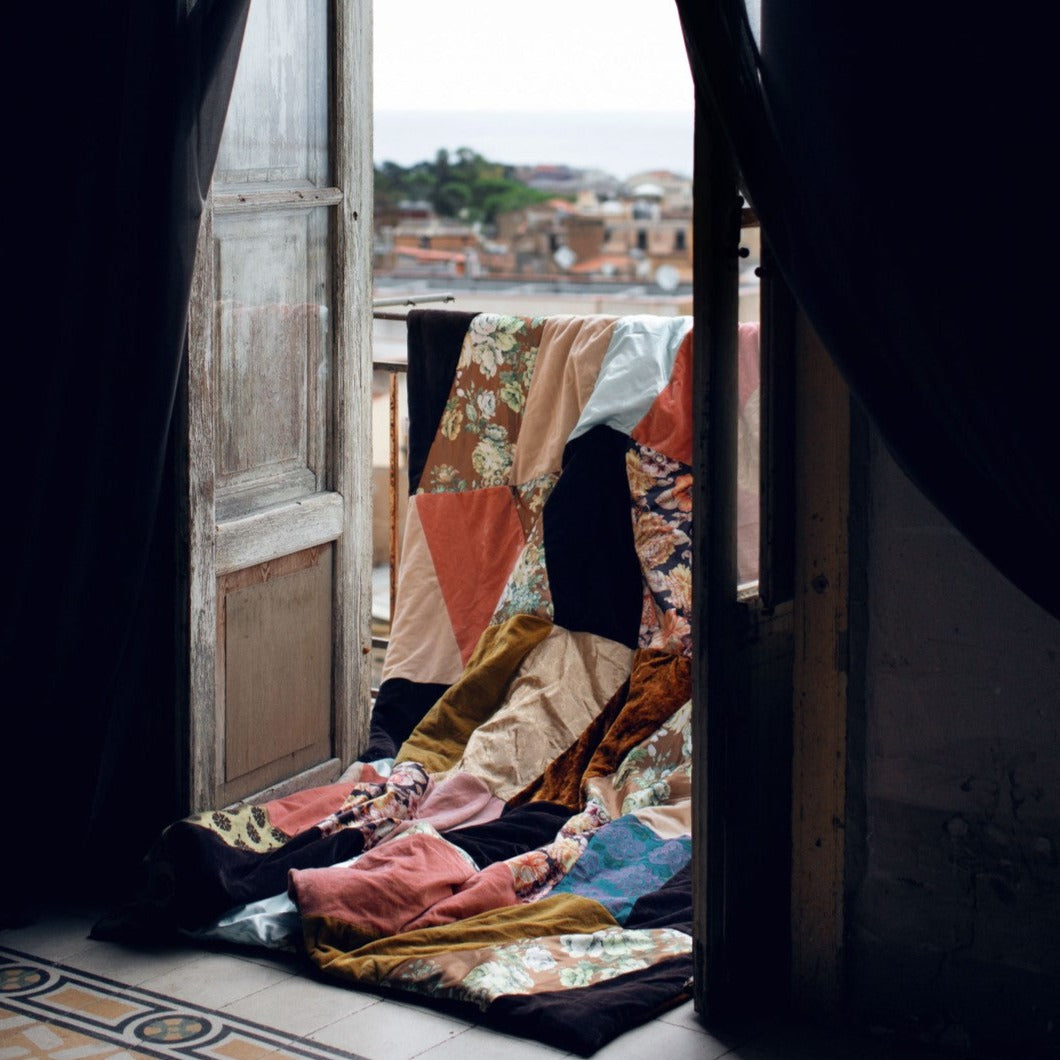 patchwork blanket hanging over balcony in Sicily
