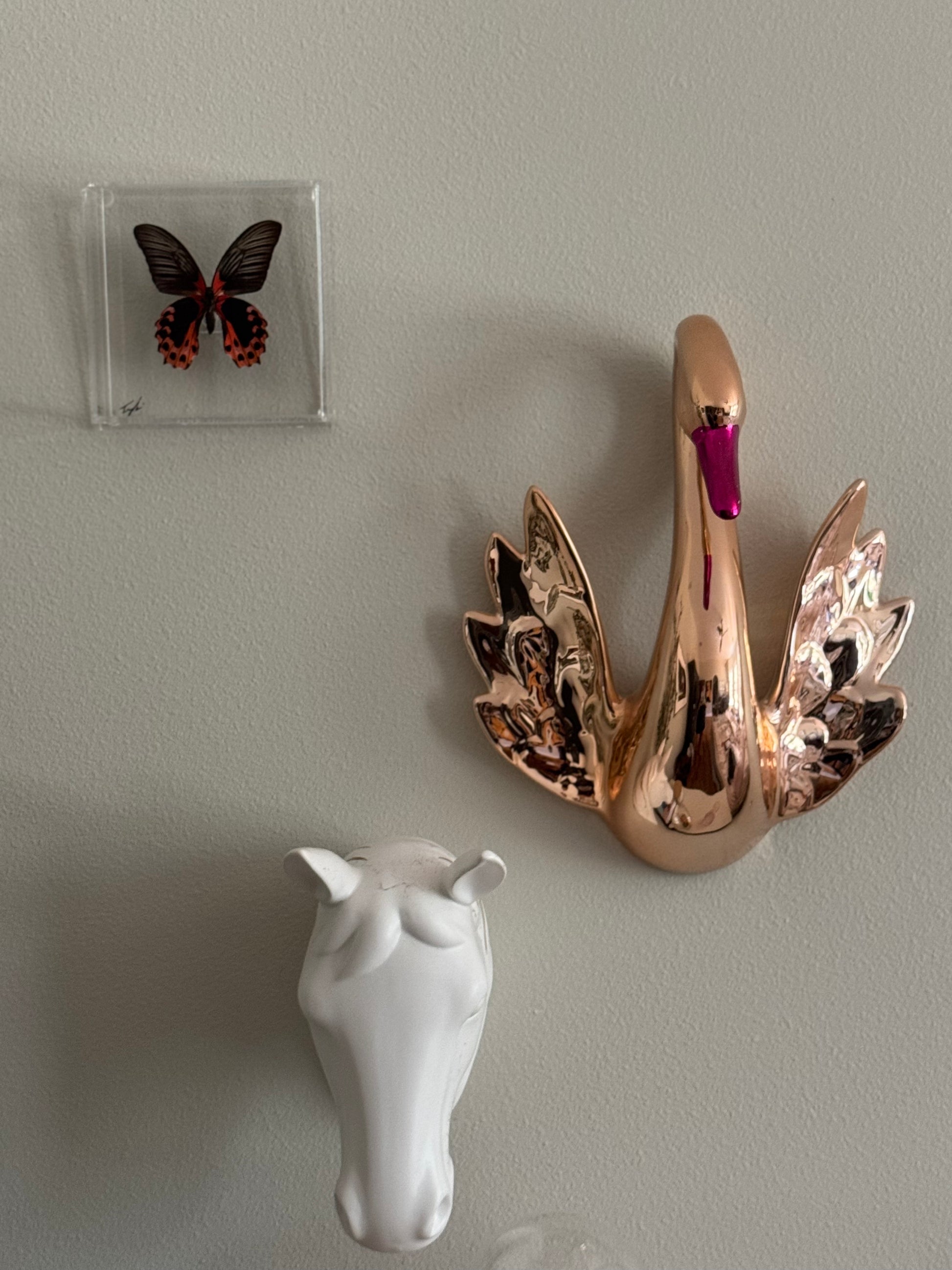 butterfly hanging on a wall with two animal decor pieces