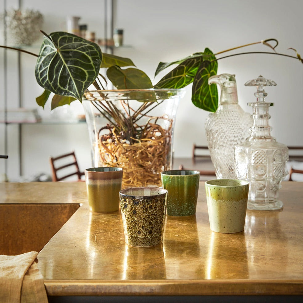 solid glass planter on marble counter top with green cups
