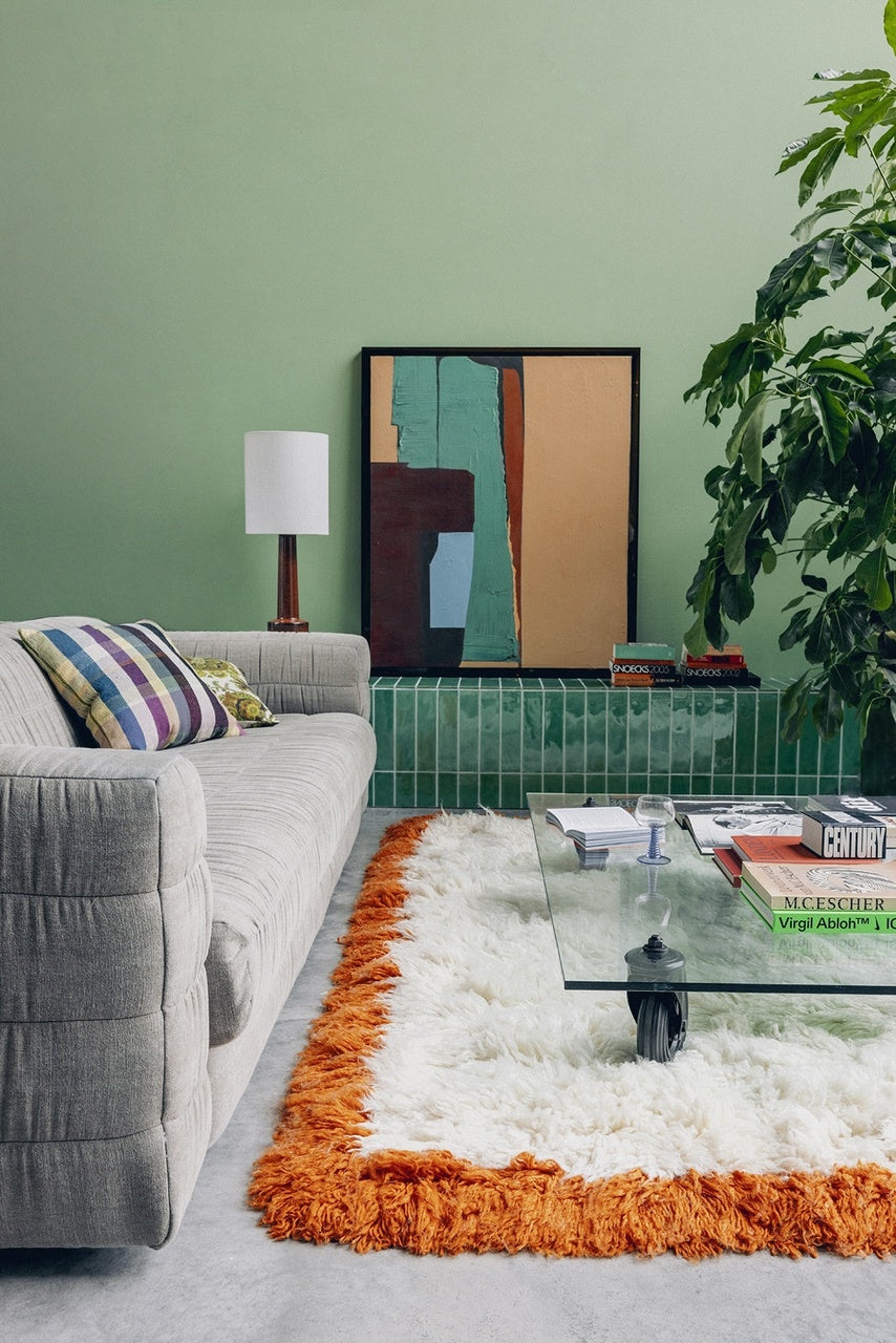 abstract painting with brown acrylic frame on green wall