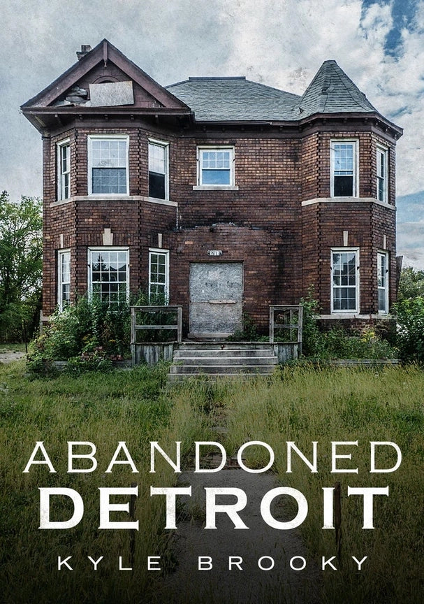 Abandoned two-story brick house with overgrown grass and weeds, titled 'Abandoned Detroit' by Kyle Brooky.