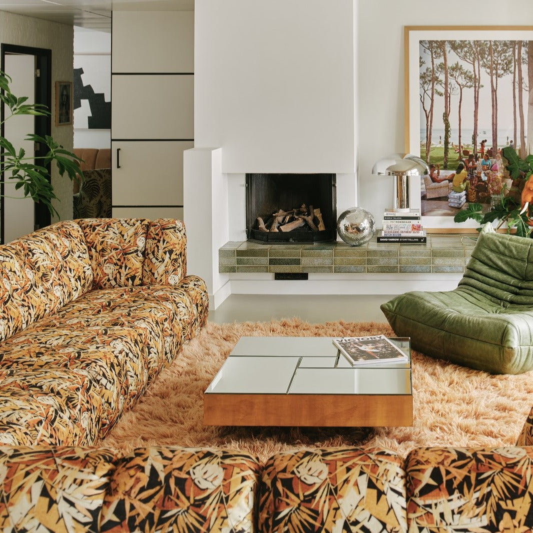 chrome table lamp in living room with printed sofa and green lounge chair