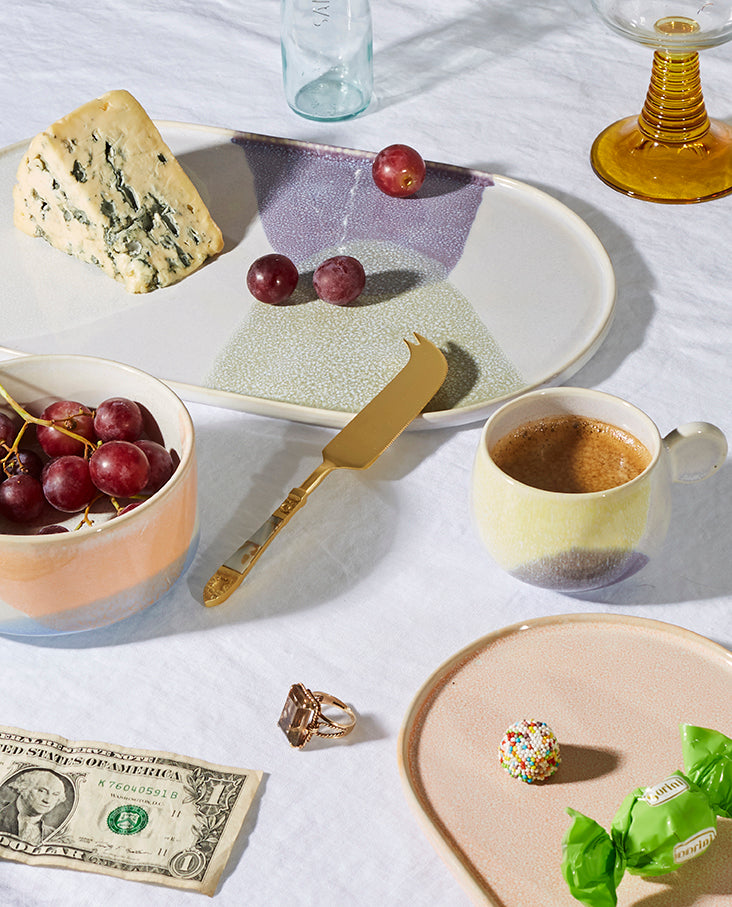 table setting with oval plate in pastel colors, coffee cups and food