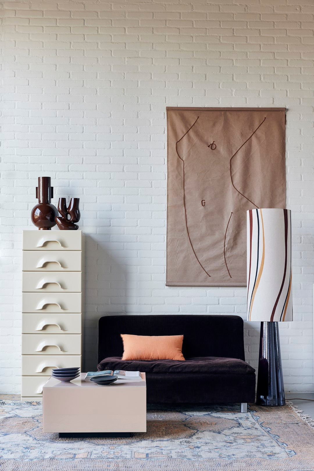 taupe beige clay colored accessories in a living room with a wall hanging and a large floor lamps