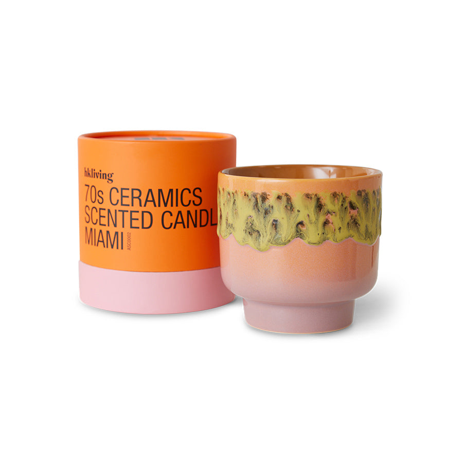 Two ceramic candles, one orange and pink with text, the other pink with a decorative pattern, on a white background.