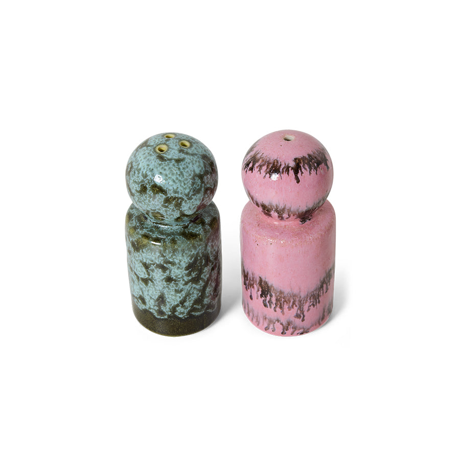 Two ceramic salt and pepper shakers, one green and one pink, on a white background.