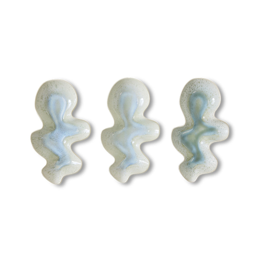 Three ceramic bowls with a wavy design on a white background