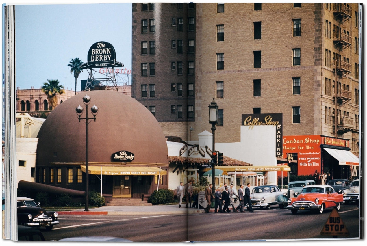 Vintage scene of a street with a prominent building labeled 'Brown Derby' and classic cars.