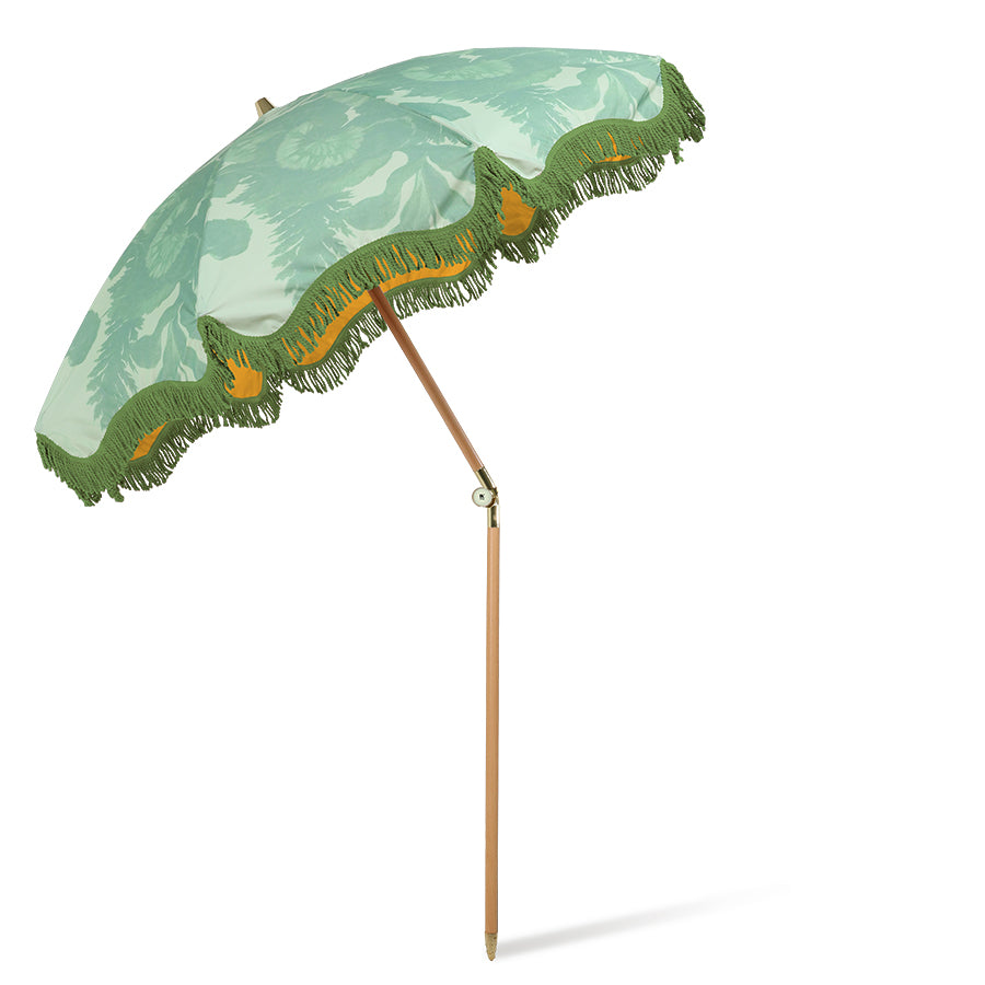 retro inspired beach umbrella in green with floral pattern and green fringes and wooden pole