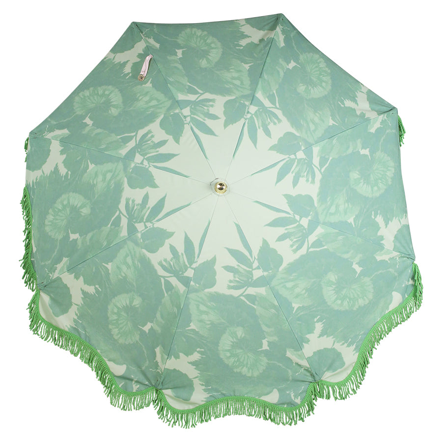 retro inspired beach umbrella in green with floral pattern and green fringes and wooden pole