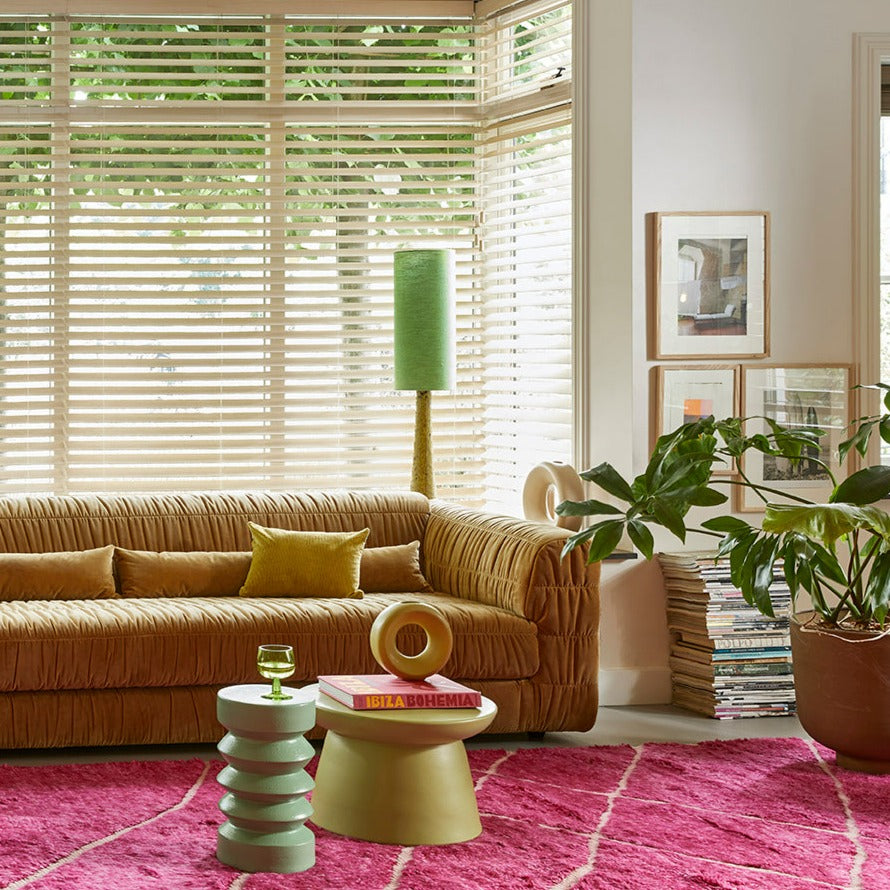 green colored accent tables on a large pink area rug