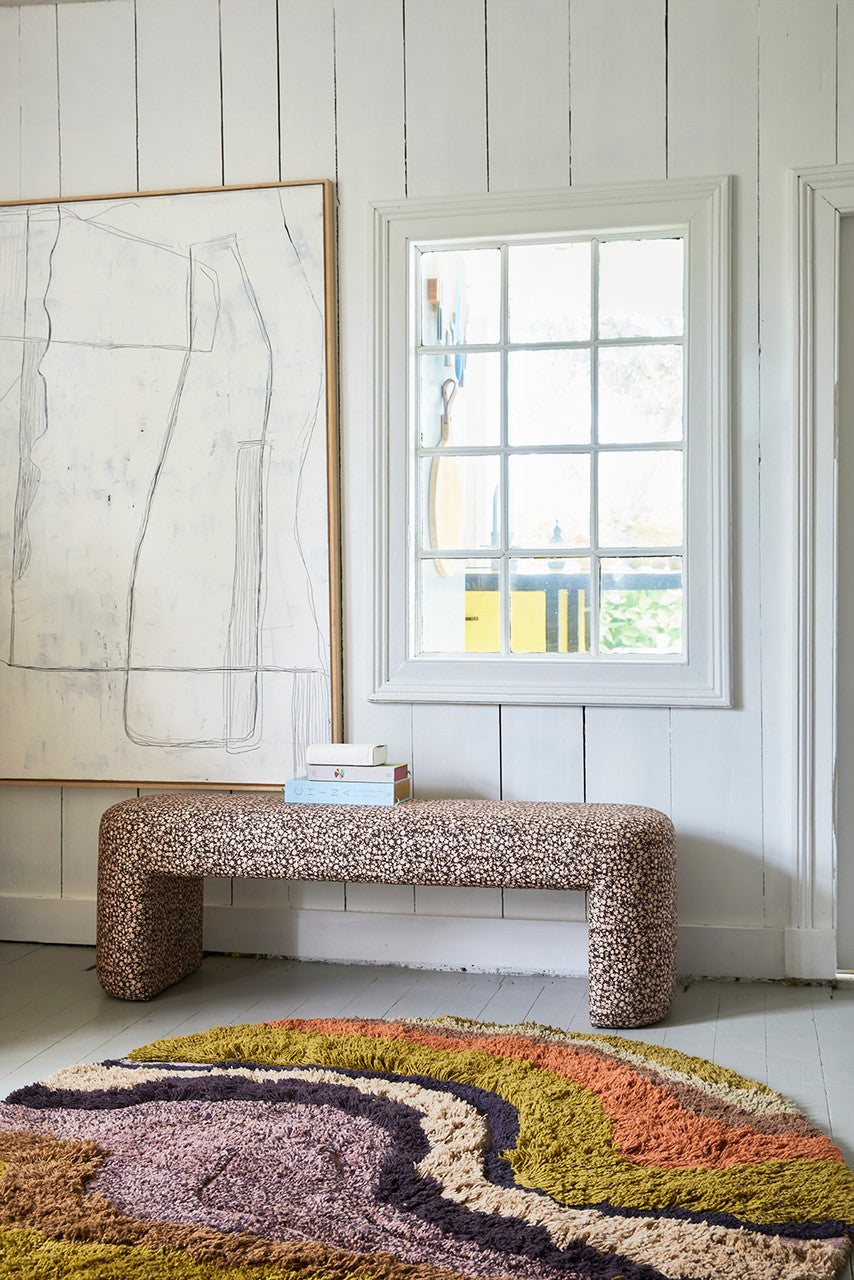 retro look upholstered lobby bench under a window