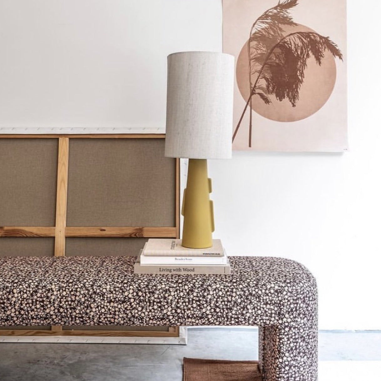 retro look upholstered lobby bench styled with lamp and books