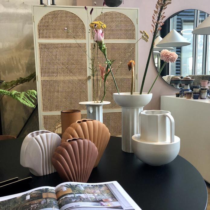black table with white and terra colored flower vases grouped together