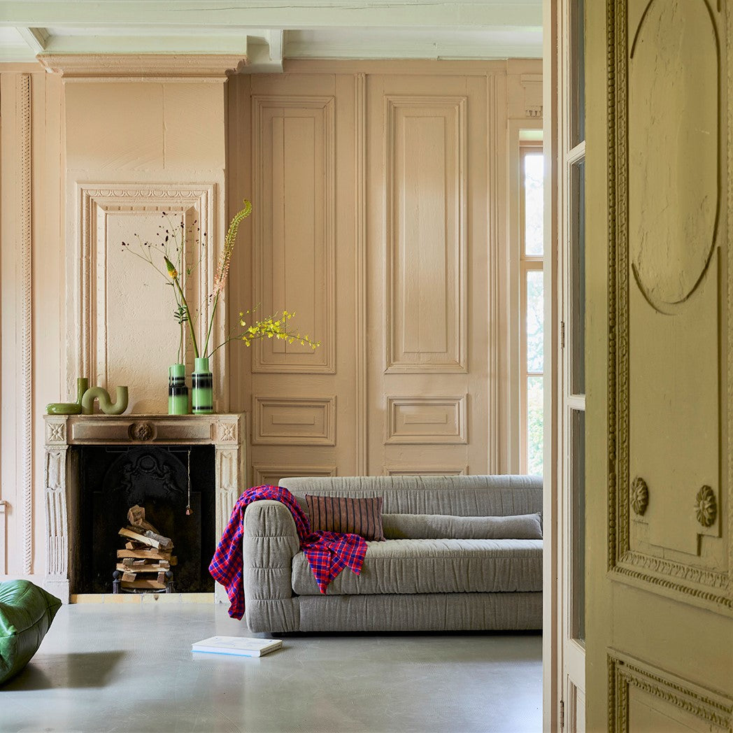 contemporary style living room with large couch and art sculptures on fire place mantel