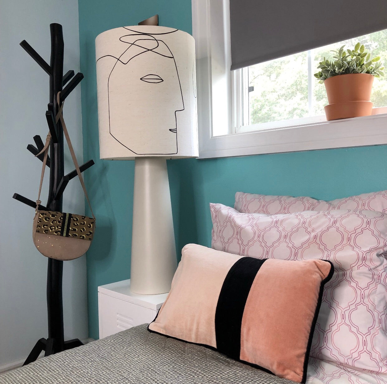 table lamp with face next to a bed in contemporary setting
