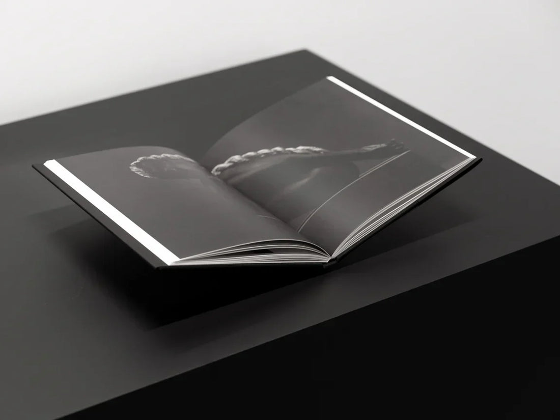 black wooden surface with a photobook on a table bookstand