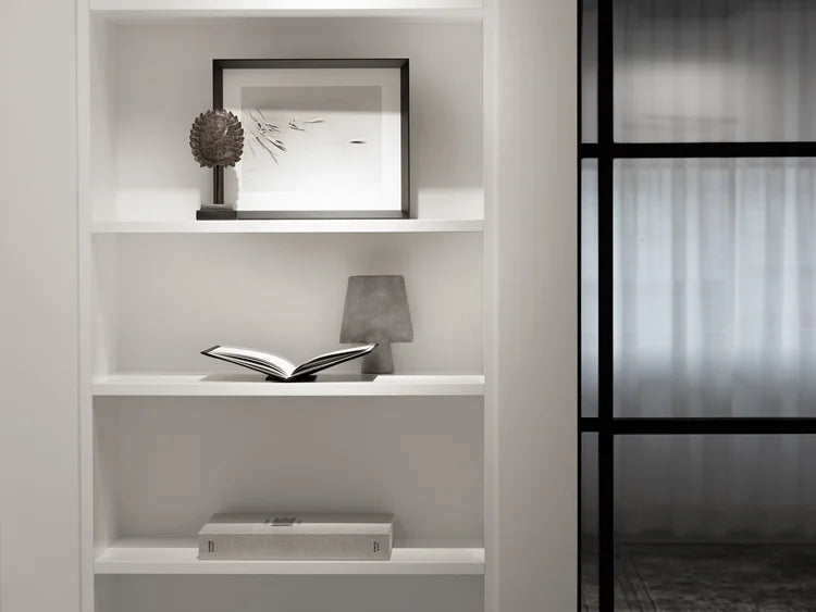 White bookshelf with decorative items in a modern interior setting