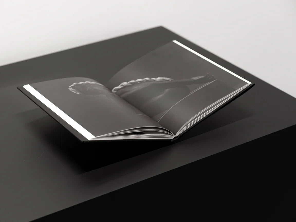 Open book on a black surface with a white background