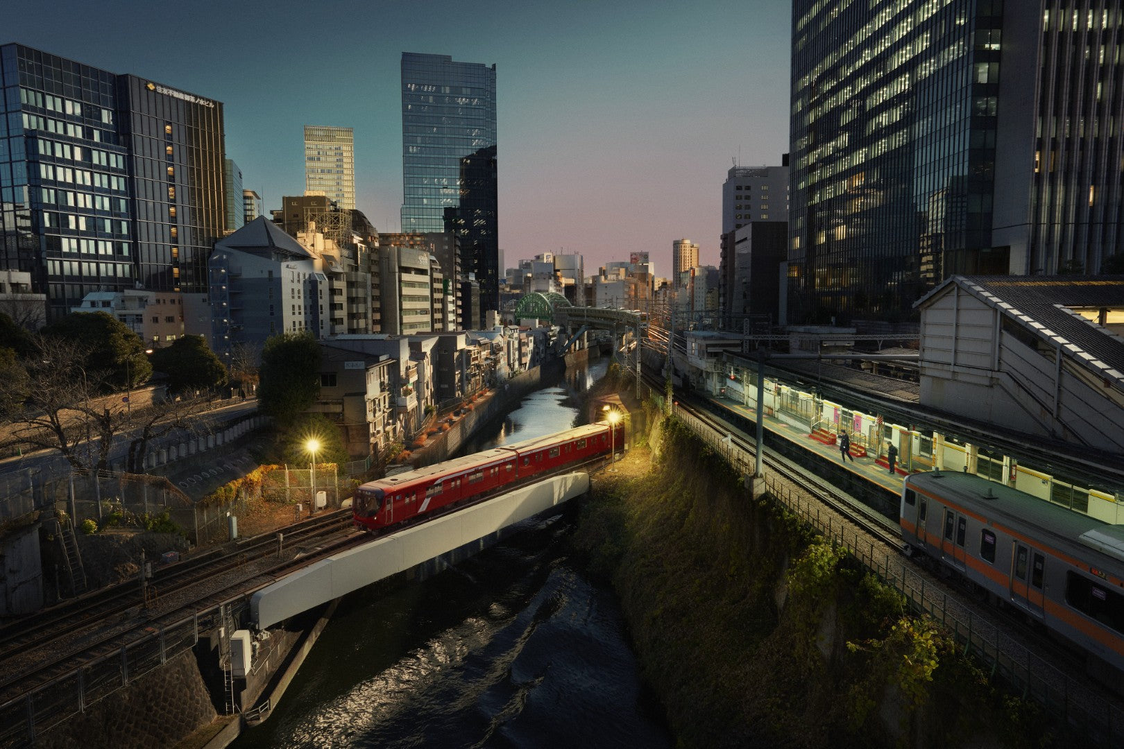 Cityscape with a train on tracks near modern buildings at dusk.