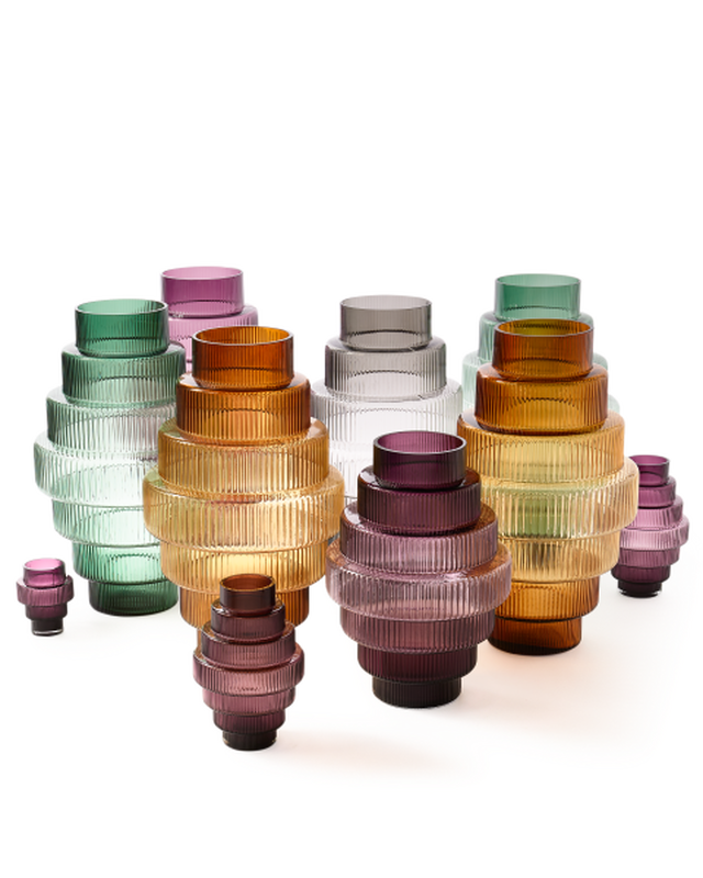Set of colorful ribbed glass vases on a white background