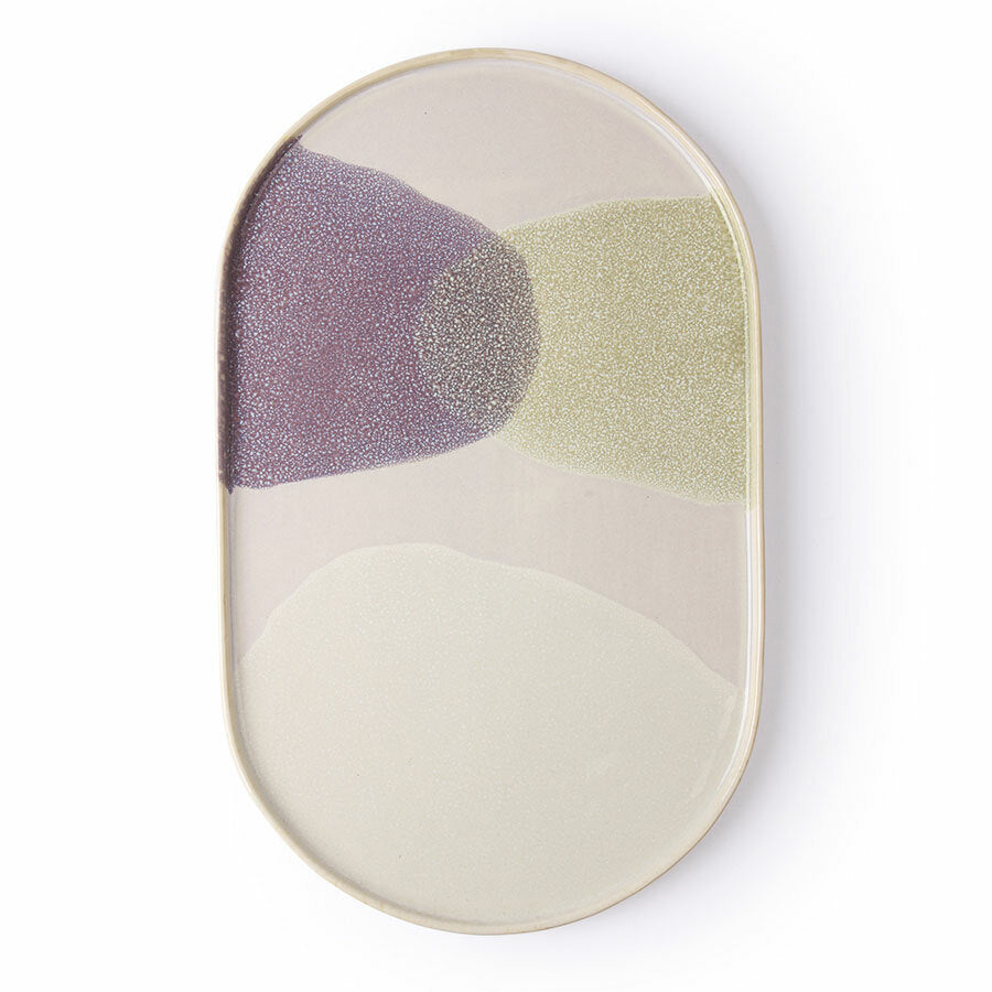 Oval ceramic plate with purple and green abstract design on a white background