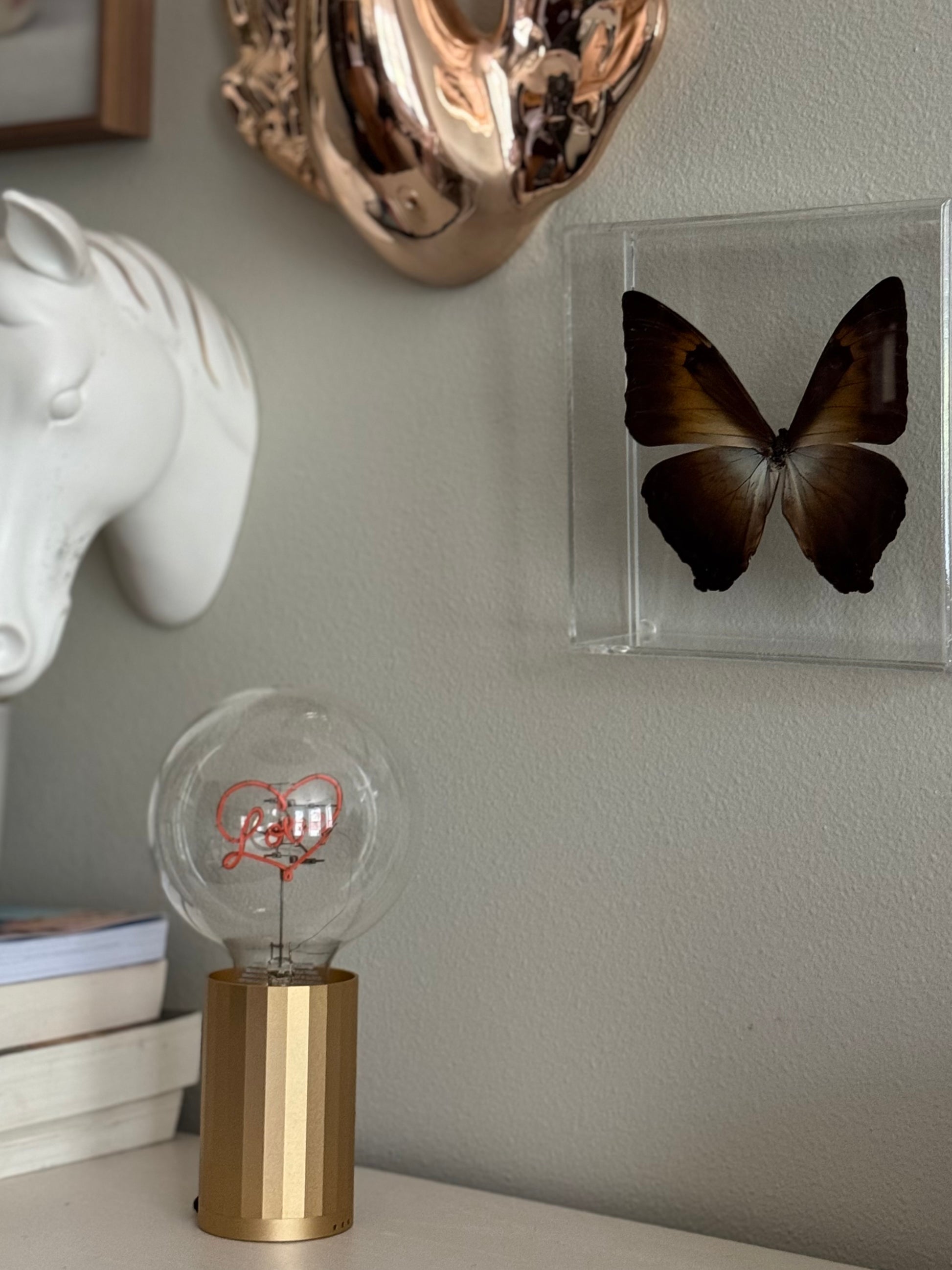 gallery wall with butterfly and sculptures