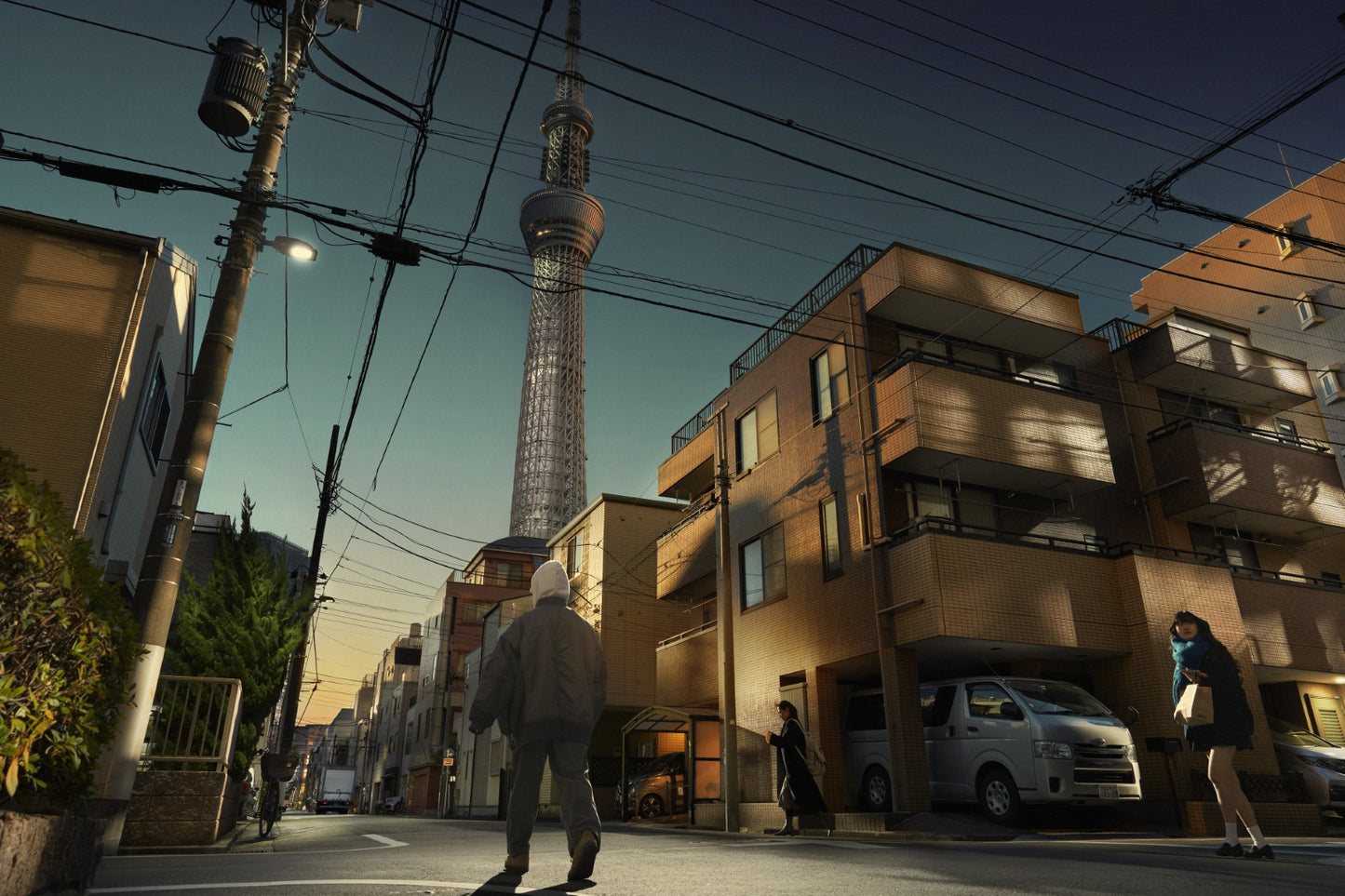 Man walking on a street with a tall tower in the background