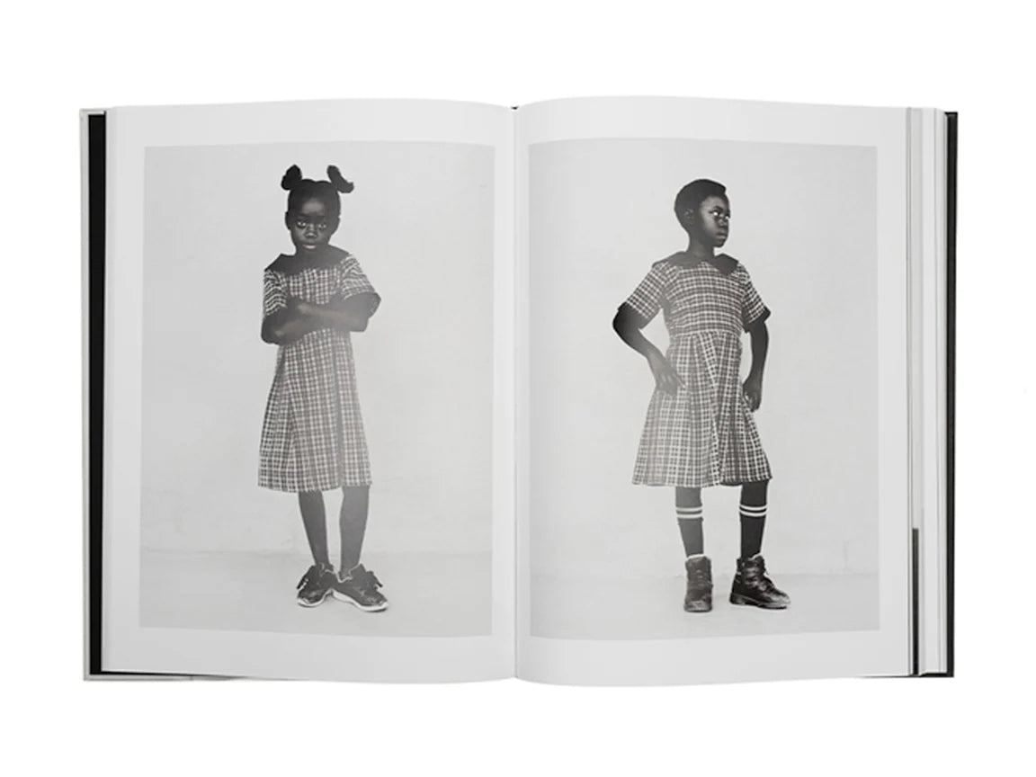 Open book showing a black and white photo of a child in a checkered dress.