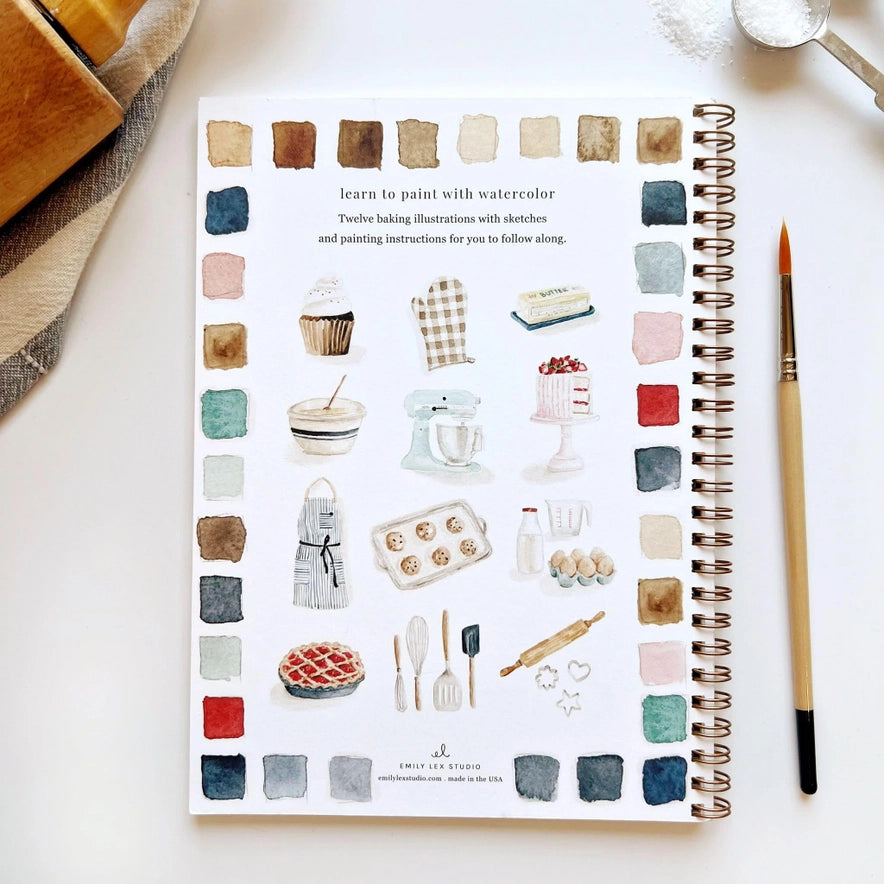 spiral notebook with baking illustrations and a paintbrush