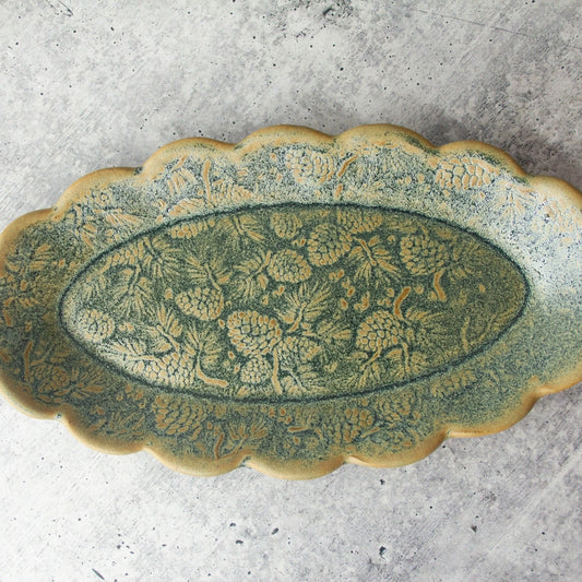 green scalloped edge oval tray with pine tree motive