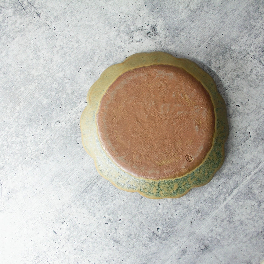 red clay green yellow round plate texture on grey background