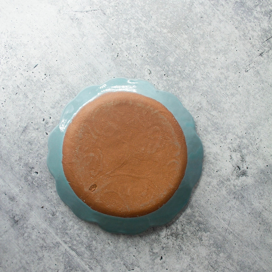 red clay turquoise bread and butter plate scalloped edge round on gray background 
