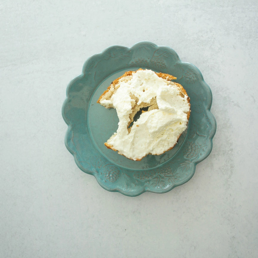 turquoise bread and butter plate with bagel scalloped edge round on gray background 