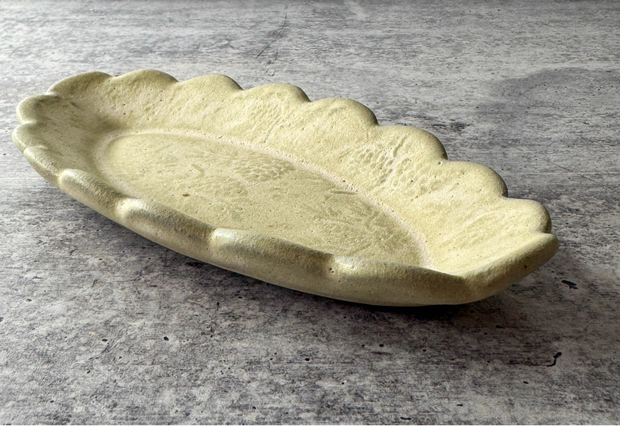 cream colored ceramic butter dish with scalloped edges