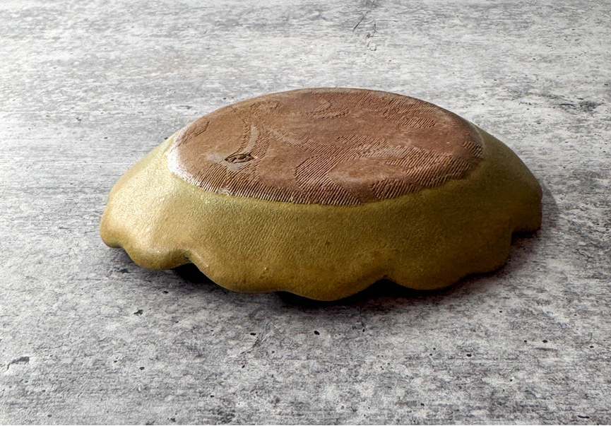 yellow and green scalloped edge plate on grey background