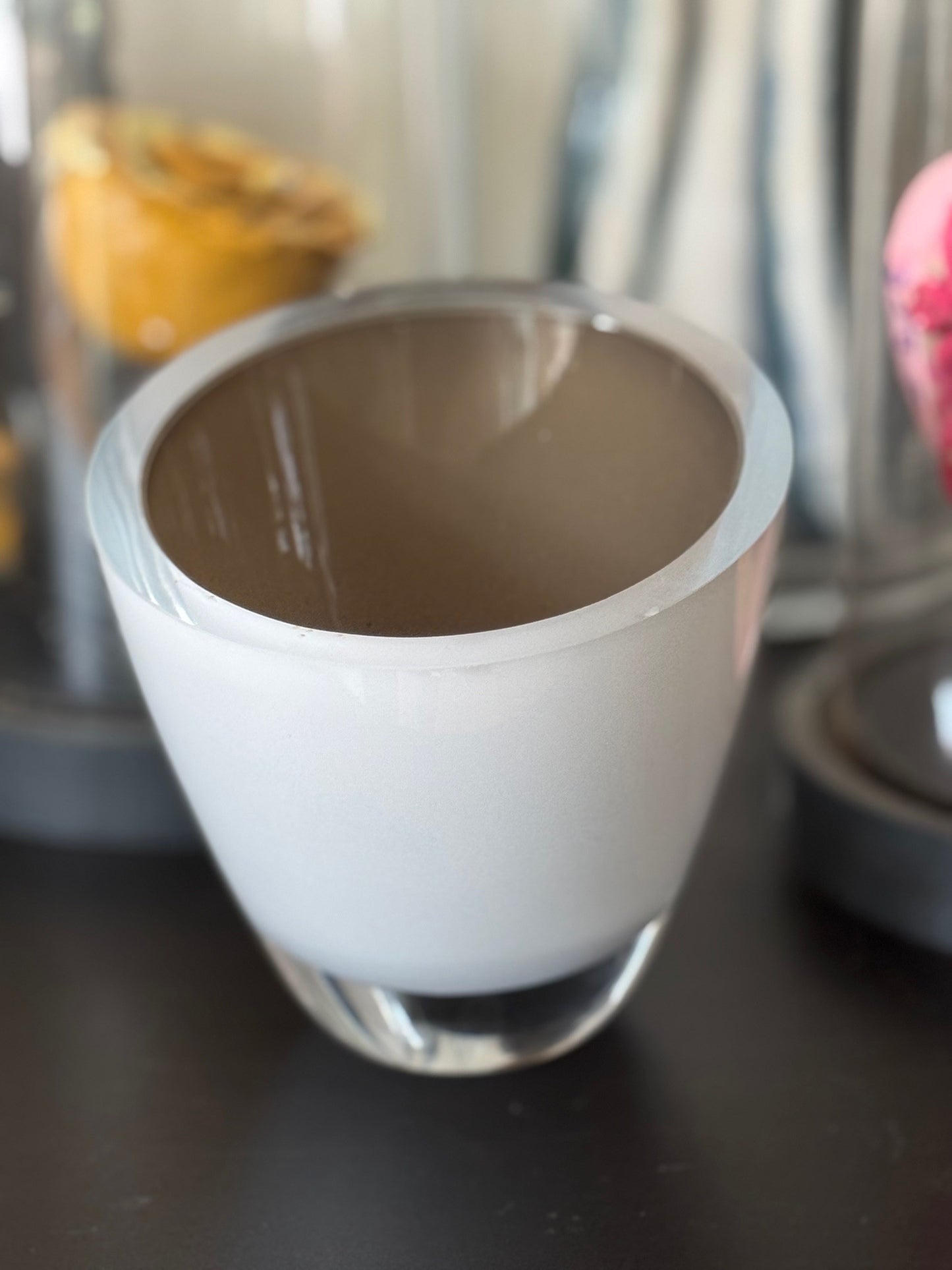 White ceramic cup with brown interior on a dark surface