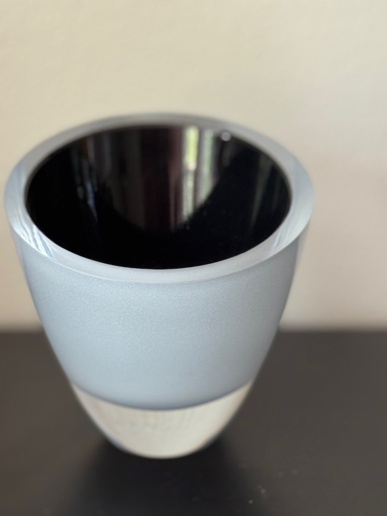 Light blue ceramic cup on a reflective surface with a neutral background