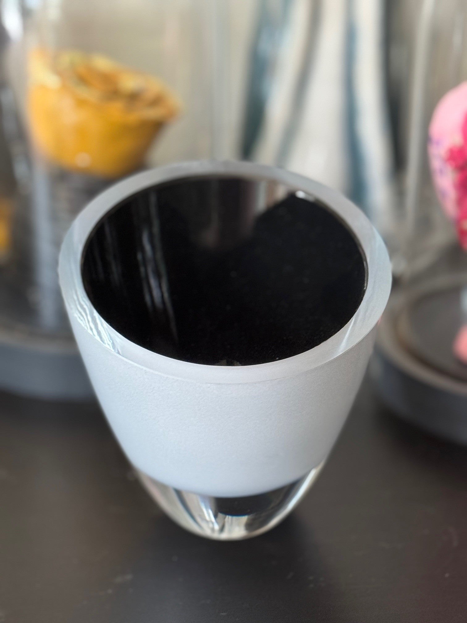White cup with black interior on a dark surface