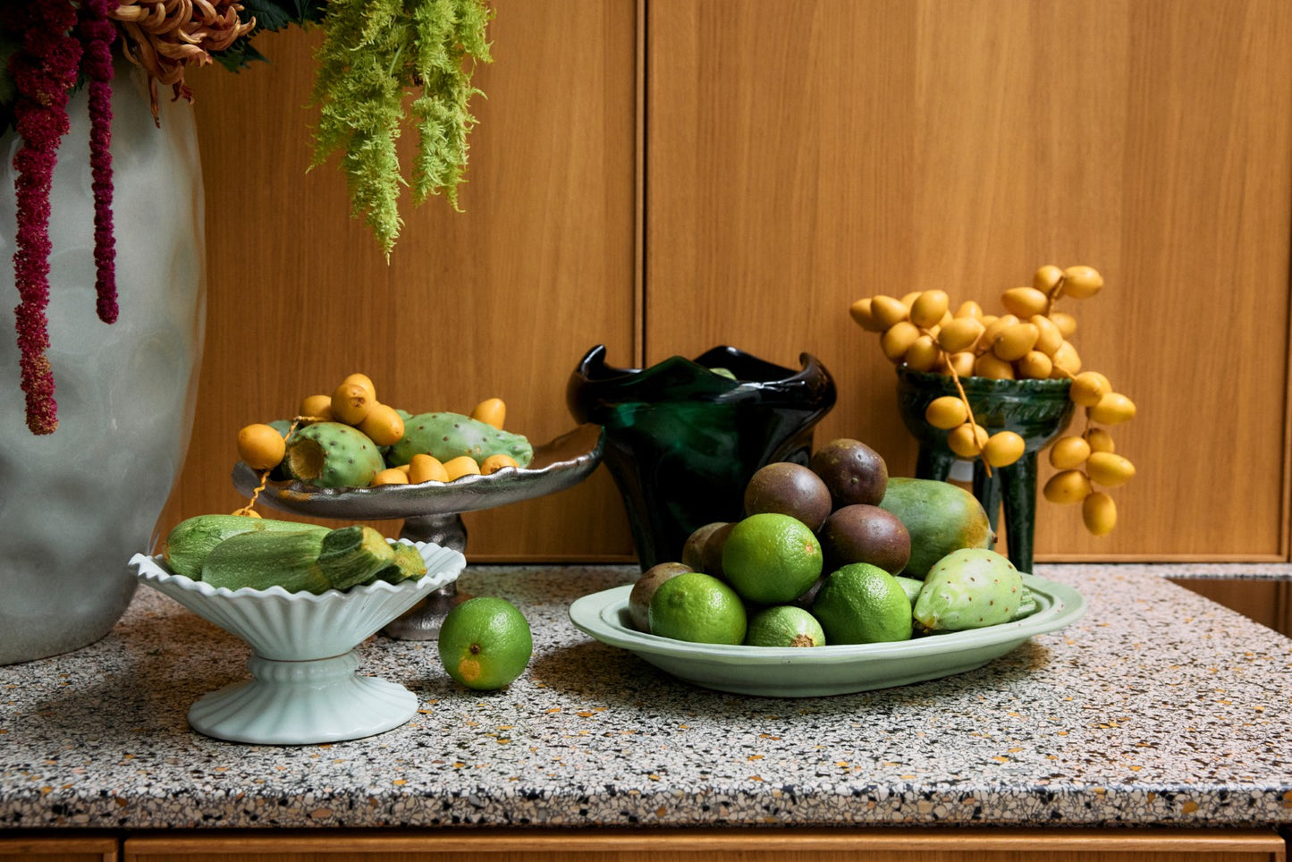 Fruits and vegetables on a kitchen counter with decorative elements.
