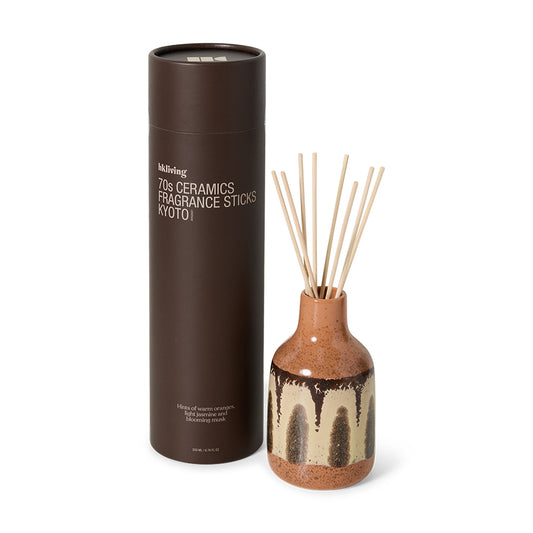 Ceramic diffuser bottle with fragrance sticks and packaging on a white background