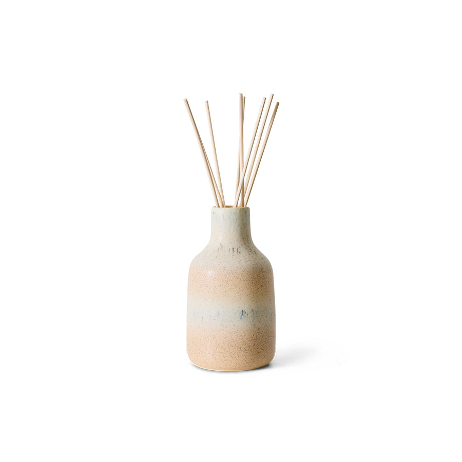 ceramic vessel in soft peach and white with reed diffuser
on white background