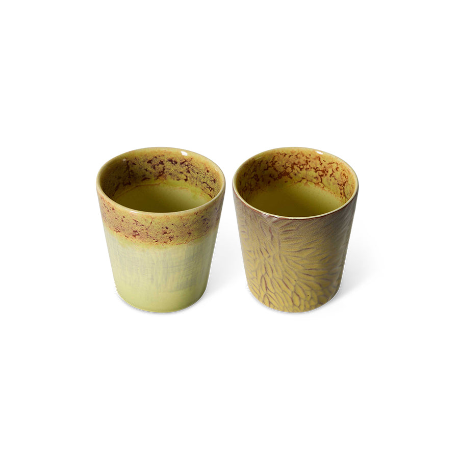 Two yellow ceramic cups with textured design on a white background